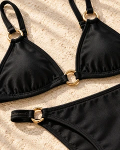 Noir — detal czarnego bikini i złotych pierścieni